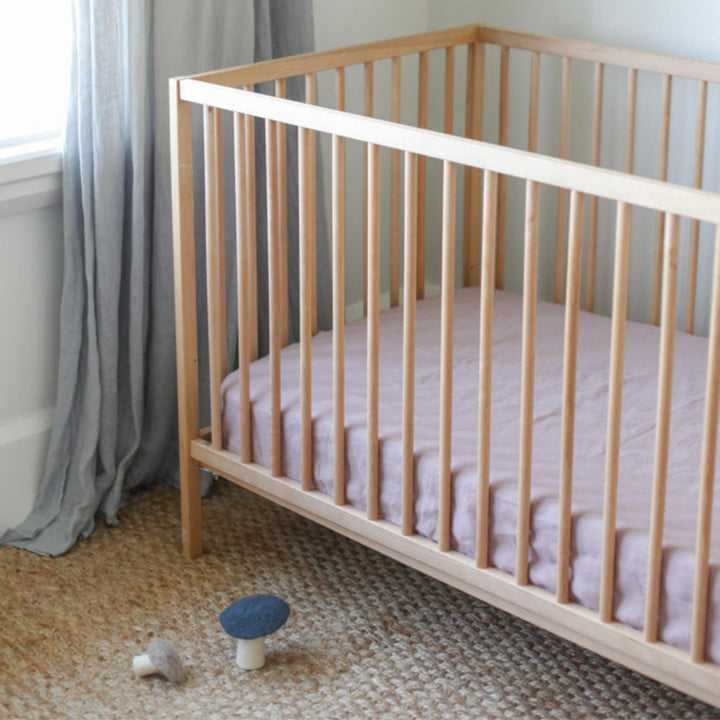 Foxtrot Home French Flax Linen styled in a baby's bedroom with Rosewood Pink Cot Sheet and Bassinet Sheets.