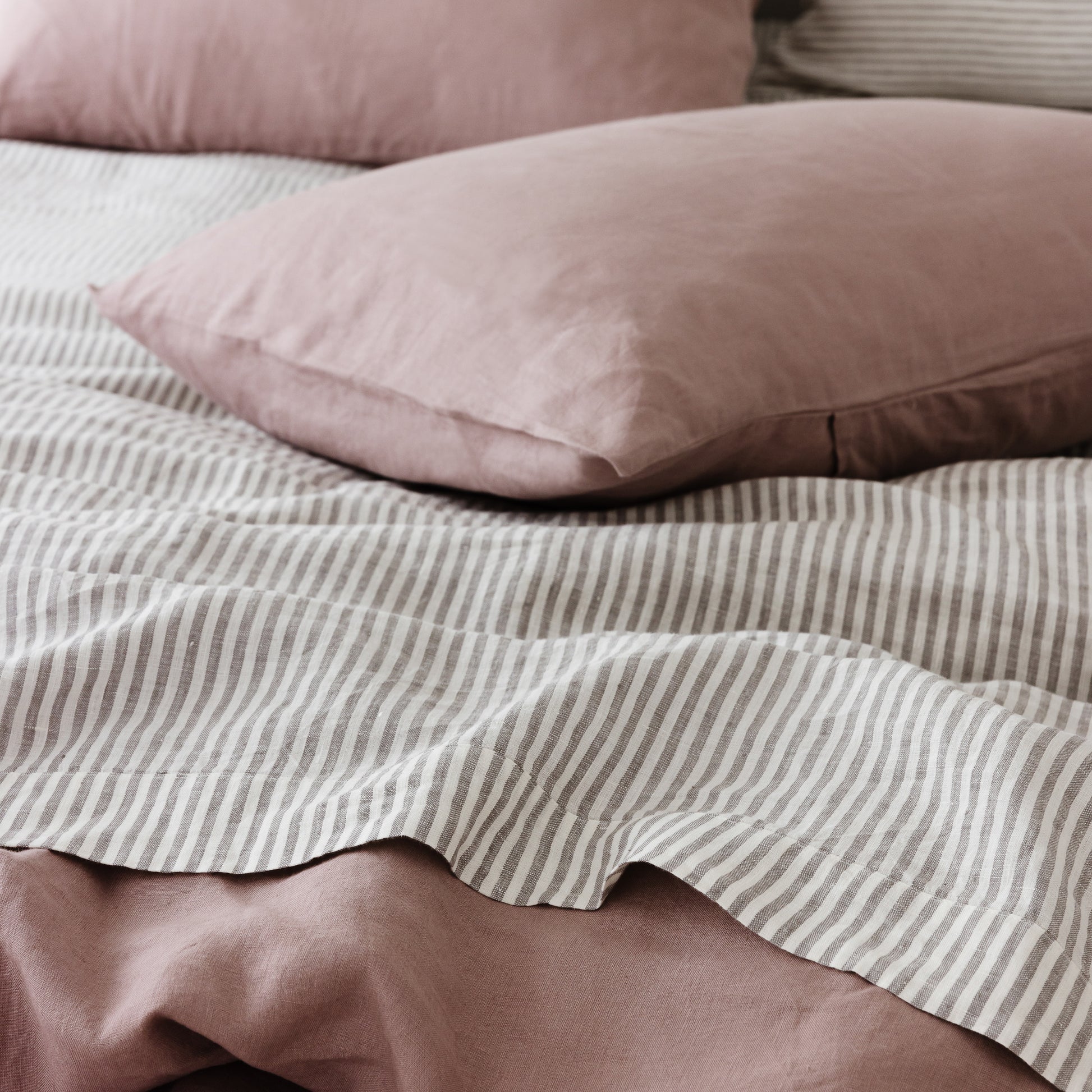 Foxtrot Home French Flax Linen styled in a bedroom with Rosewood Duvet, Grey Stripes and Pillowcases.
