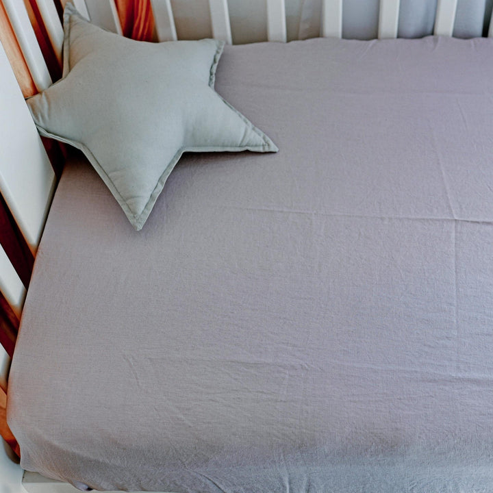 Foxtrot Home French Flax Linen styled in a baby's bedroom with Lilac Purple Cot Sheet and Bassinet Sheets.