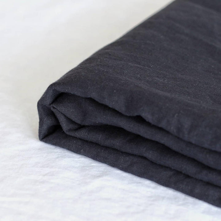 Foxtrot Home French Flax Linen styled in a baby's bedroom with Midnight Blue Cot Sheet and Bassinet Sheets.