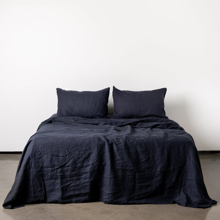 Foxtrot Home French Flax Linen styled in a bedroom with Midnight Blue Fitted Sheet.