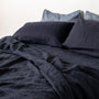 Foxtrot Home French Flax Linen styled in a bedroom with Midnight Blue Fitted Sheet.