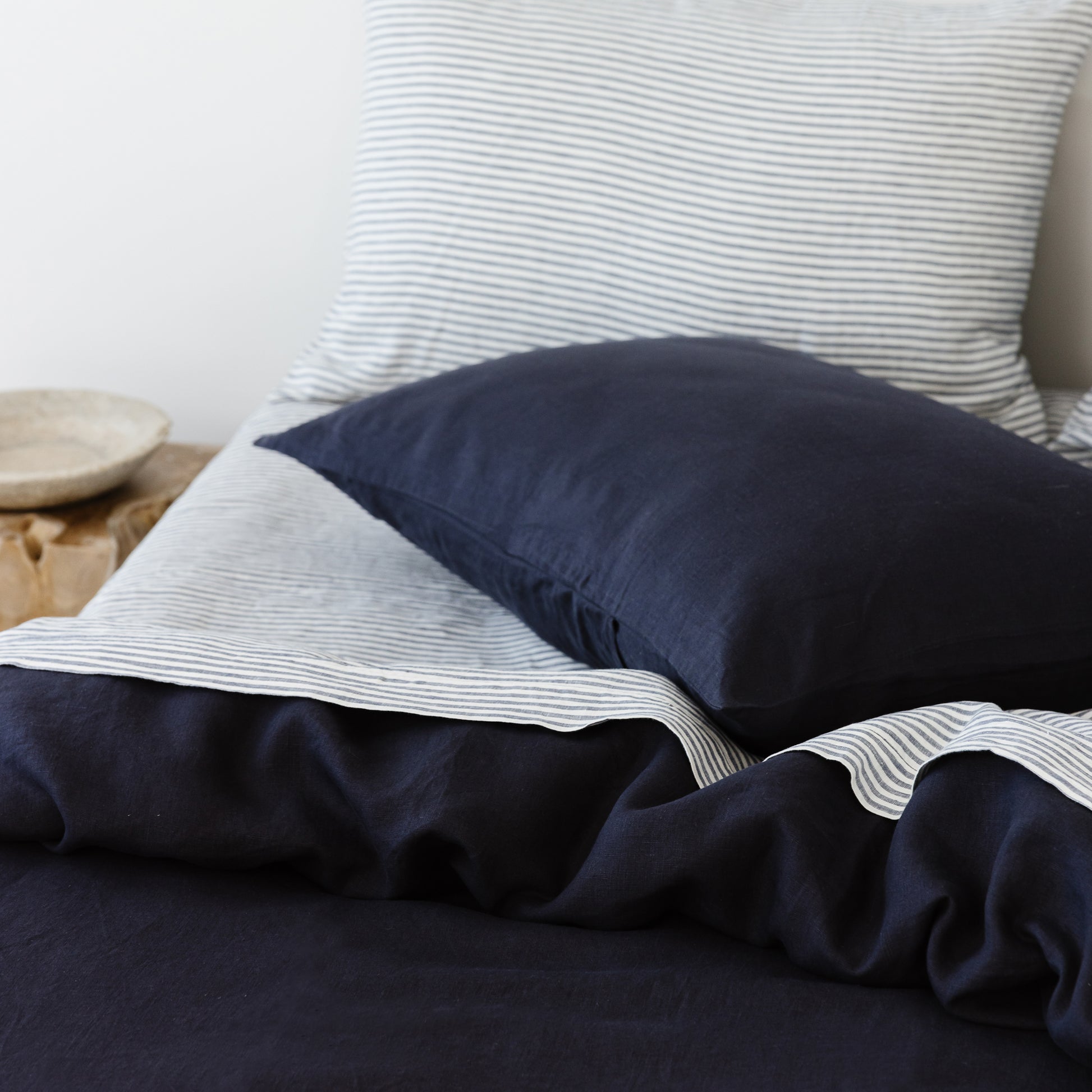 Foxtrot Home French Flax Linen styled in a bedroom with Midnight Blue Pillowcases.