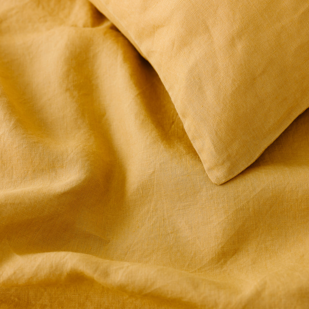 Foxtrot Home French Flax Linen styled in a bedroom with Mustard Yellow Duvet.