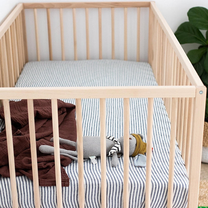 Foxtrot Home French Flax Linen styled in a baby's bedroom with Navy Stripes Cot Sheet and Bassinet Sheets.