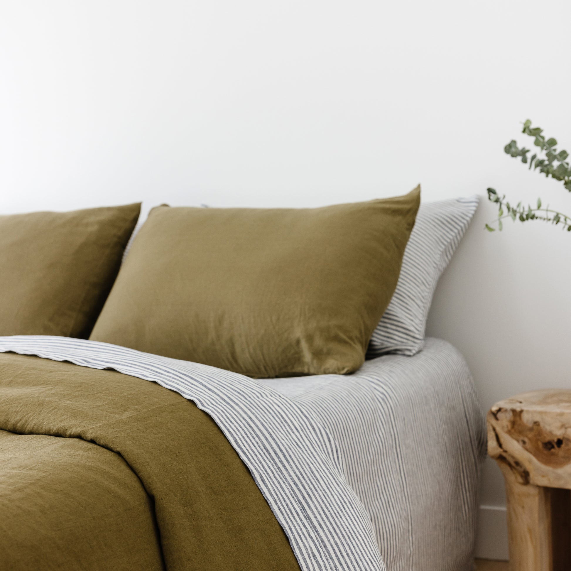 Foxtrot Home French Flax Linen styled in a bedroom with Olive Green Duvet, Navy Blue Sheets Set and Pillowcases.
