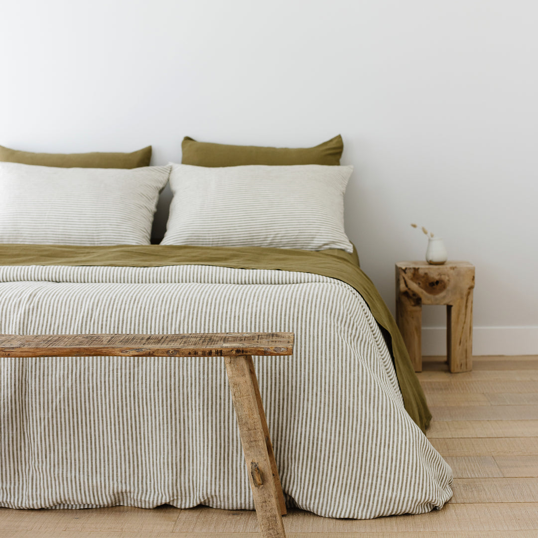 Foxtrot Home French Flax Linen styled in a bedroom with Olive Stripes Duvet, Olive Green Sheets Set and Pillowcases.