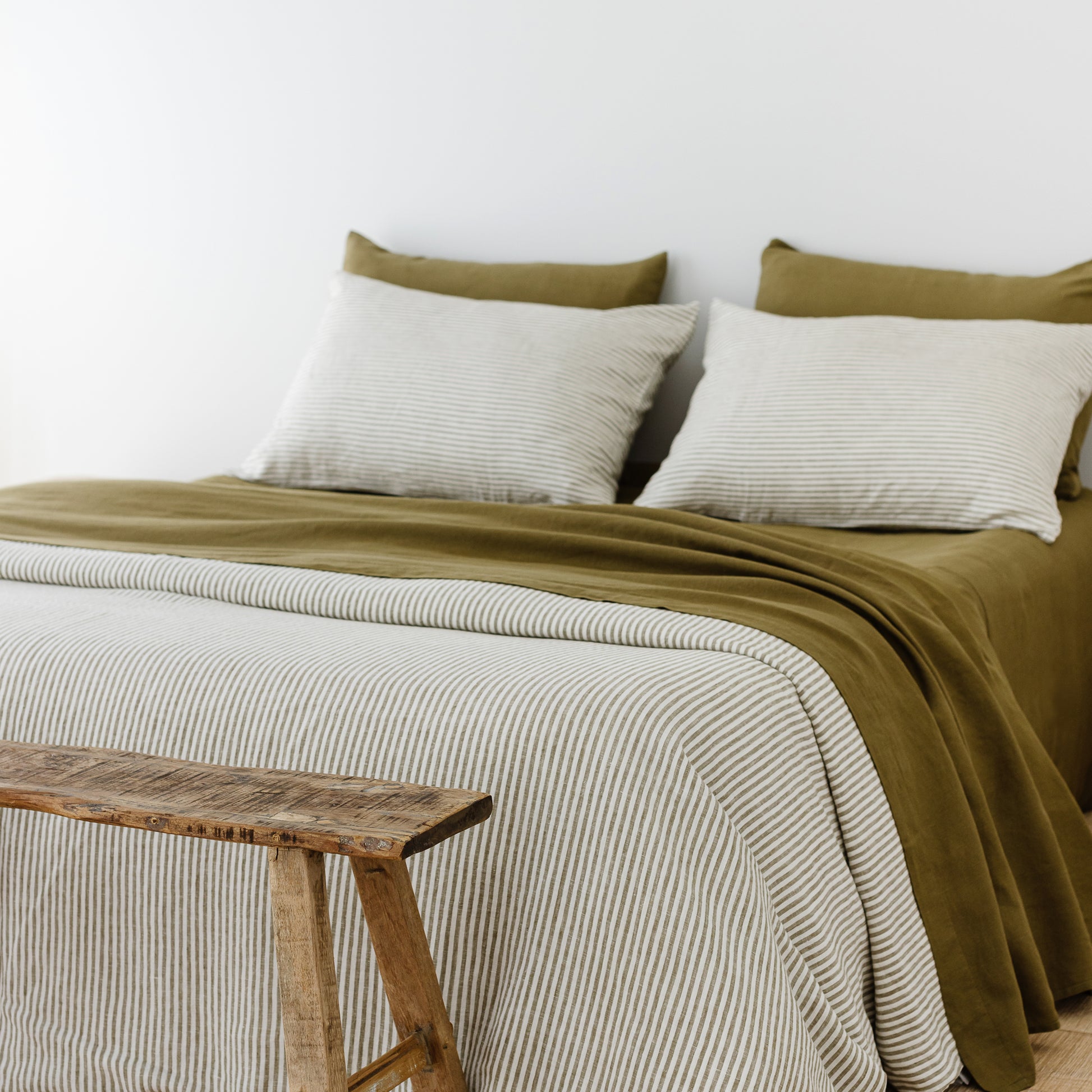 Foxtrot Home French Flax Linen styled in a bedroom with Olive Stripes Duvet, Olive Green Sheets Set and Pillowcases.