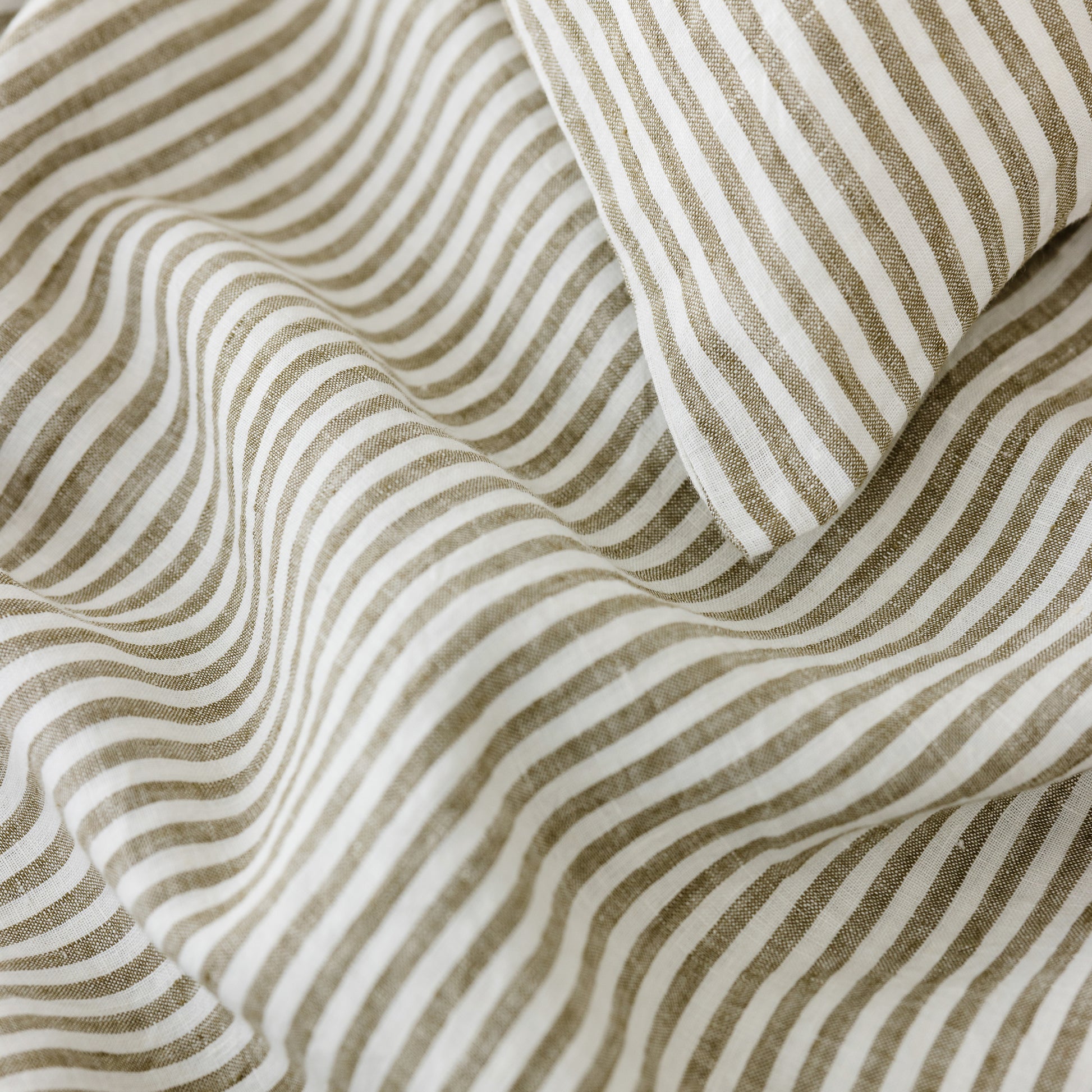 Foxtrot Home French Flax Linen styled in a bedroom with Olive Stripes Duvet, Olive Green Sheets Set and Pillowcases.
