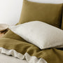 Foxtrot Home French Flax Linen styled in a bedroom with Olive Stripes Duvet, Olive Green Sheets Set and Pillowcases.