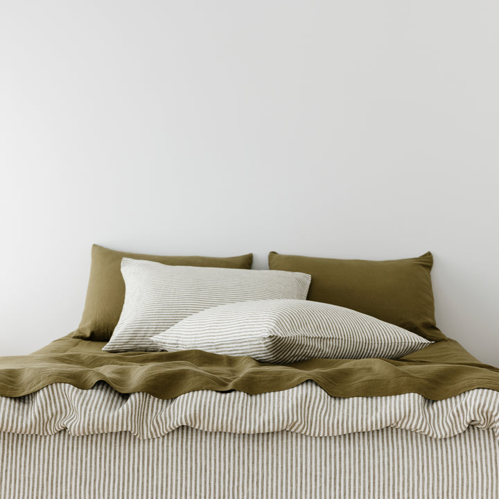Foxtrot Home French Flax Linen styled in a bedroom with Olive Stripes Duvet, Olive Green Sheets Set and Pillowcases.