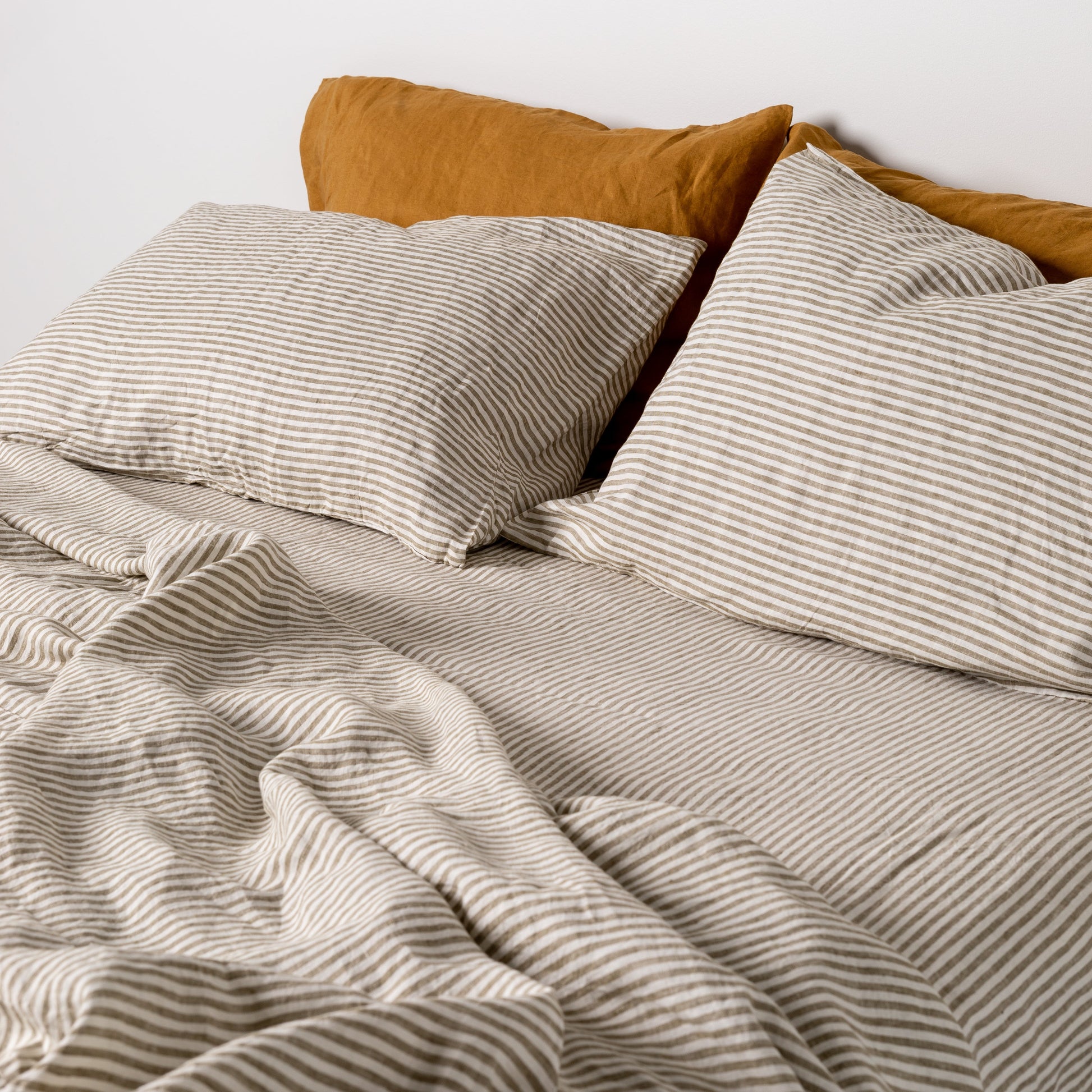 Foxtrot Home French Flax Linen styled in a bedroom with Olive Green Stripes Fitted Sheet.