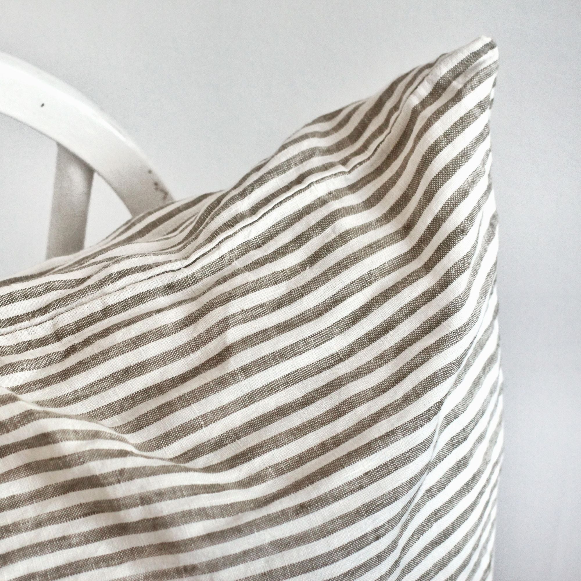 Foxtrot Home French Flax Linen styled in a bedroom with Olive Green Stripes Cushion Cover.