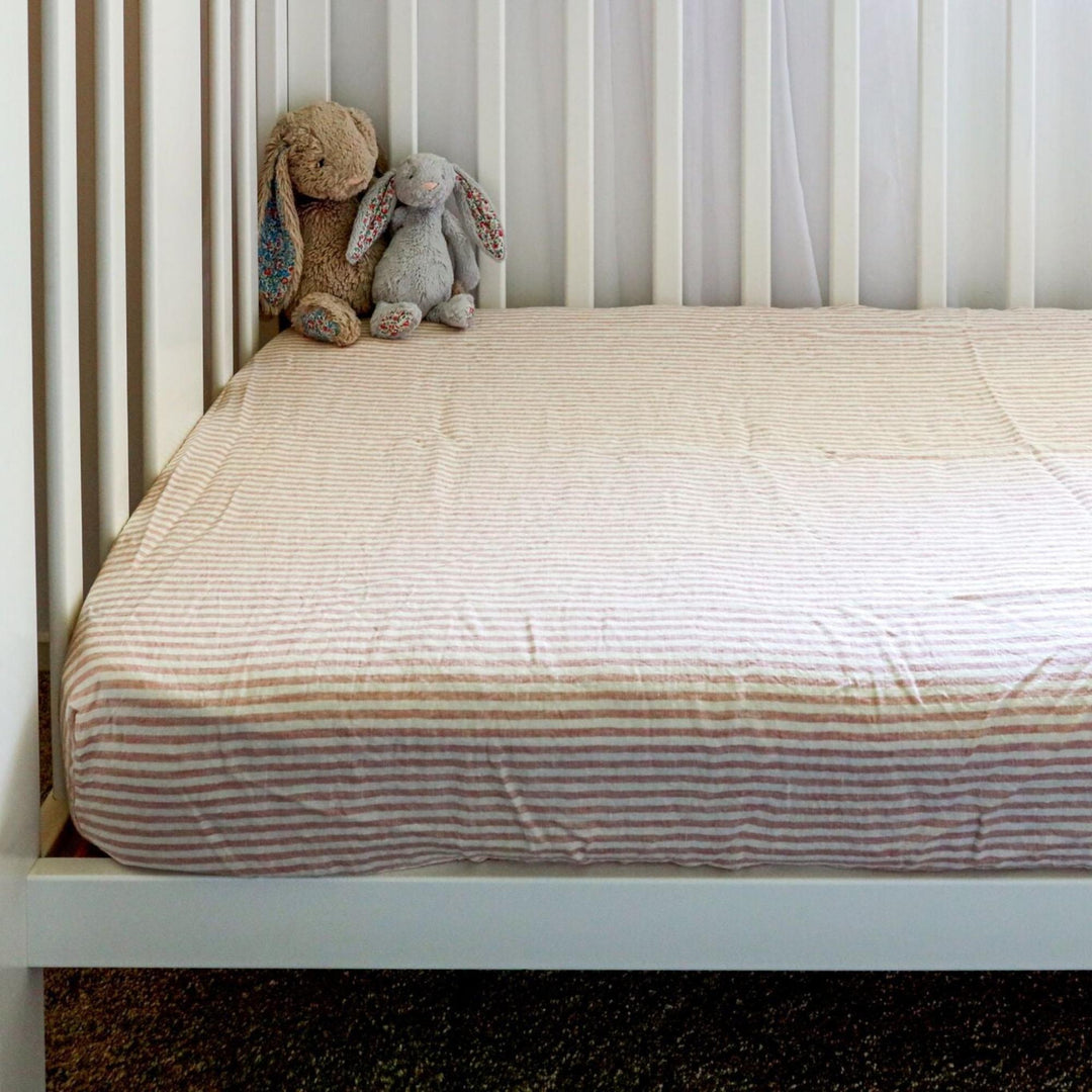Foxtrot Home French Flax Linen styled in a baby's bedroom with Pink Stripes Cot Sheet and Bassinet Sheets.