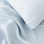 Foxtrot Home French Flax Linen styled in a bedroom with Powder Blue Duvet, Grey Stripes Sheets Sets and Pillowcases.