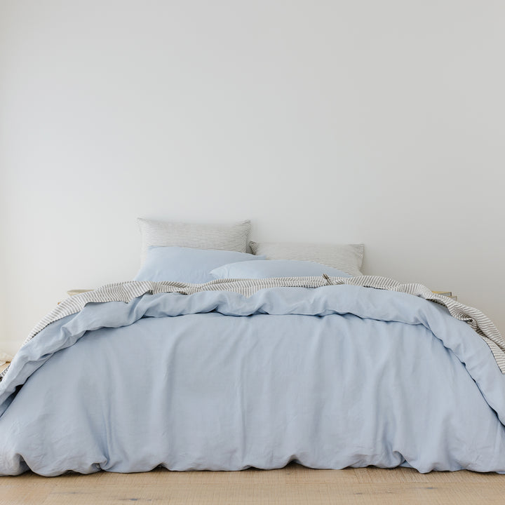 Foxtrot Home French Flax Linen styled in a bedroom with Powder Blue Duvet, Grey Stripes Sheets Sets and Pillowcases.