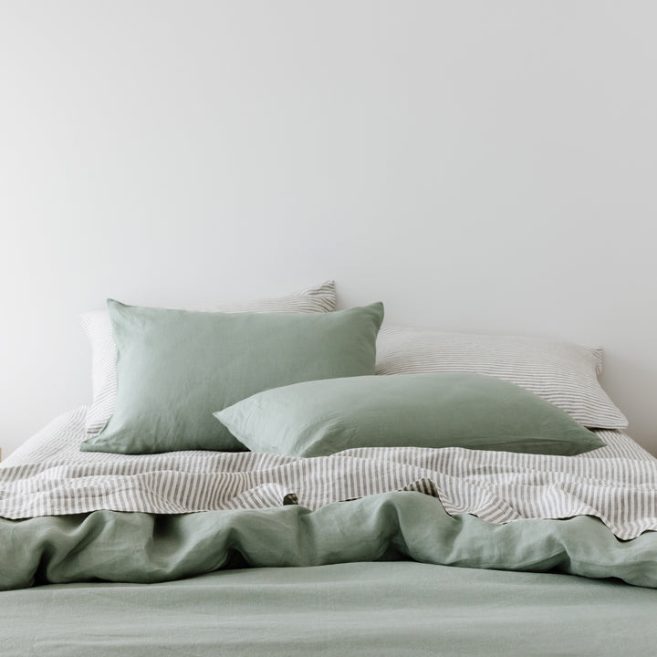 Foxtrot Home French Flax Linen styled in a bedroom with Sage Green Duvet, Grey Stripes Sheets and Pillowcases.