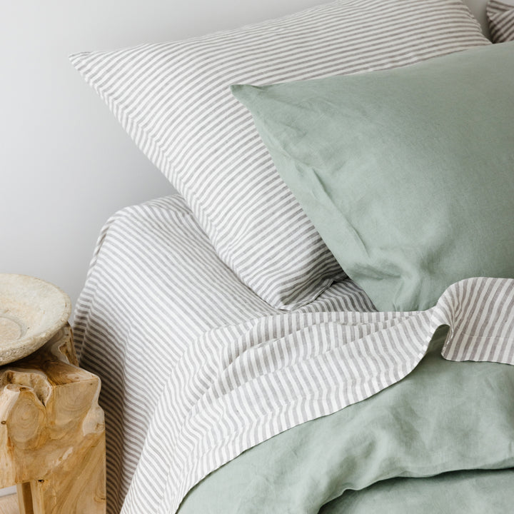 Foxtrot Home French Flax Linen styled in a bedroom with Sage Green Duvet, Grey Stripes Sheets and Pillowcases.