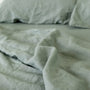 Foxtrot Home French Flax Linen styled in a bedroom with Sage Green Sheets Set.