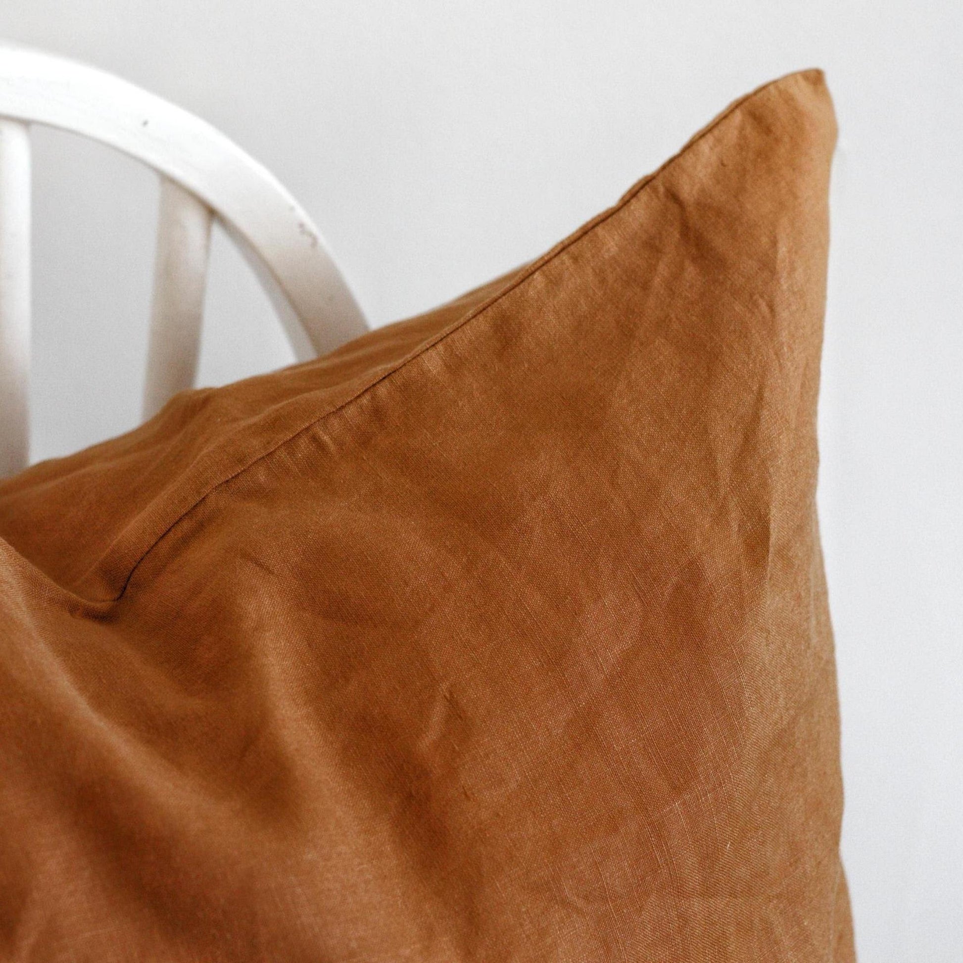Foxtrot Home French Flax Linen styled in a bedroom with Tobacco Cushion Cover.
