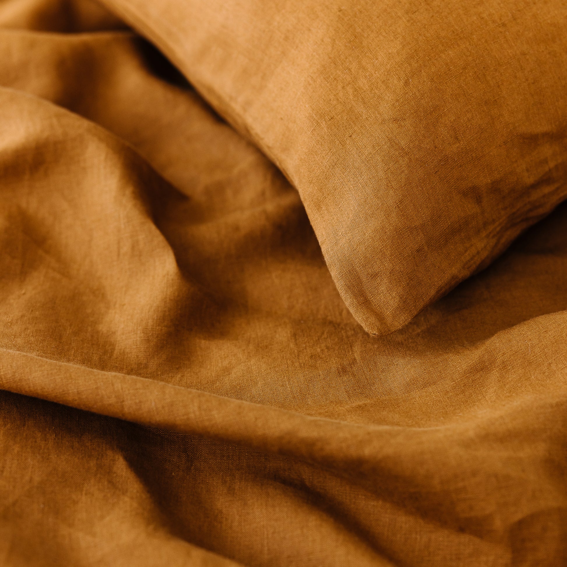 Foxtrot Home French Flax Linen styled in a bedroom with Tobacco Cushion Cover.