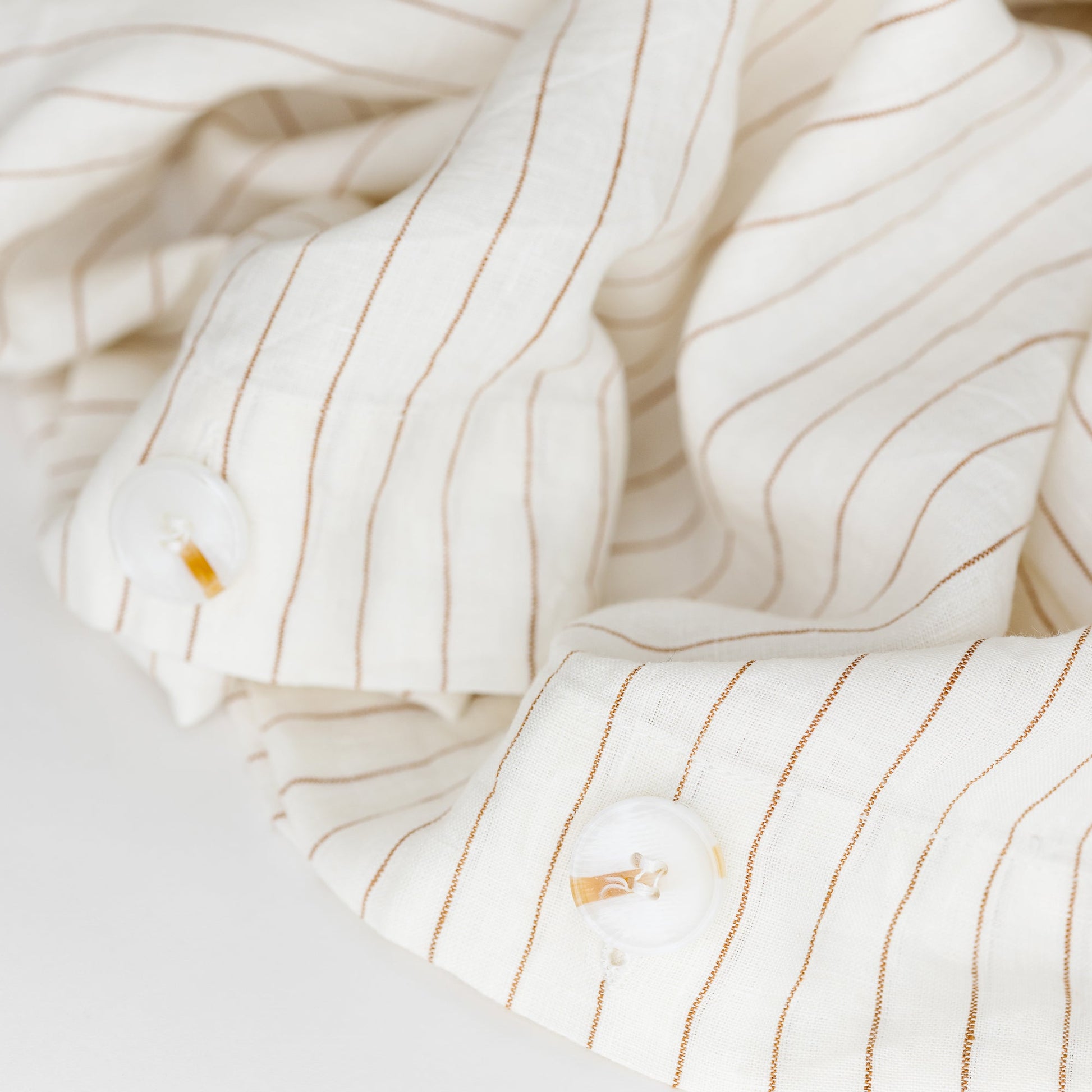 Foxtrot Home French Flax Linen styled in a bedroom with Tobacco Stripes Duvet, Oat Sheets Set and Pillowcases.