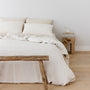 Foxtrot Home French Flax Linen styled in a bedroom with Tobacco Stripes Duvet, Oat Sheets Set and Pillowcases.
