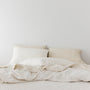 Foxtrot Home French Flax Linen styled in a bedroom with Tobacco Stripes Duvet, Oat Sheets Set and Pillowcases.