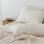 Foxtrot Home French Flax Linen styled in a bedroom with Tobacco Stripes Duvet, Oat Sheets Set and Pillowcases.