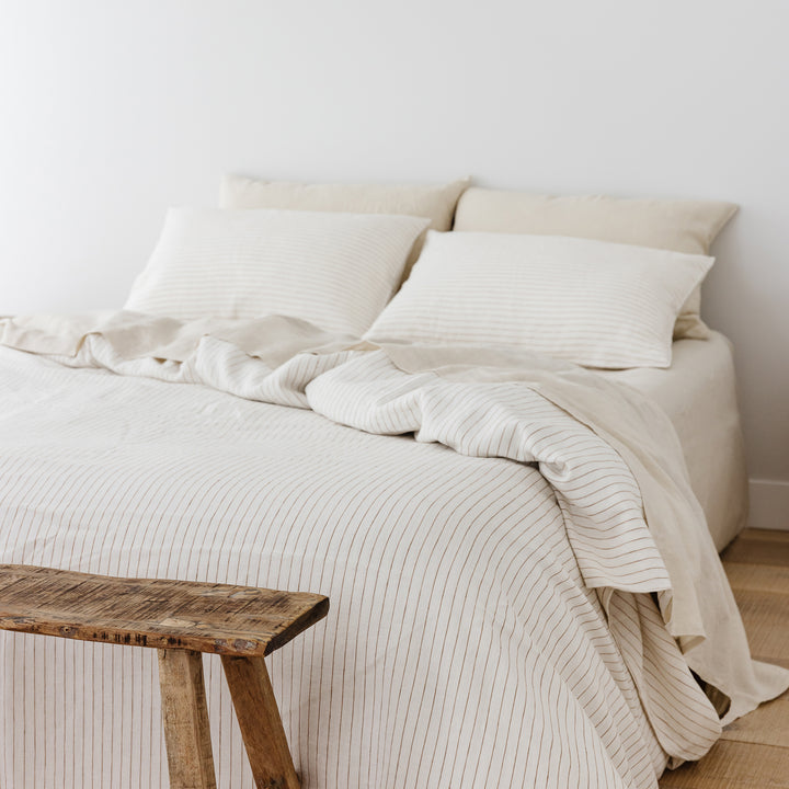 Foxtrot Home French Flax Linen styled in a bedroom with Tobacco Stripes Duvet, Oat Sheets Set and Pillowcases.
