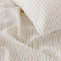 Foxtrot Home French Flax Linen styled in a bedroom with Tobacco Stripes Duvet, Oat Sheets Set and Pillowcases.