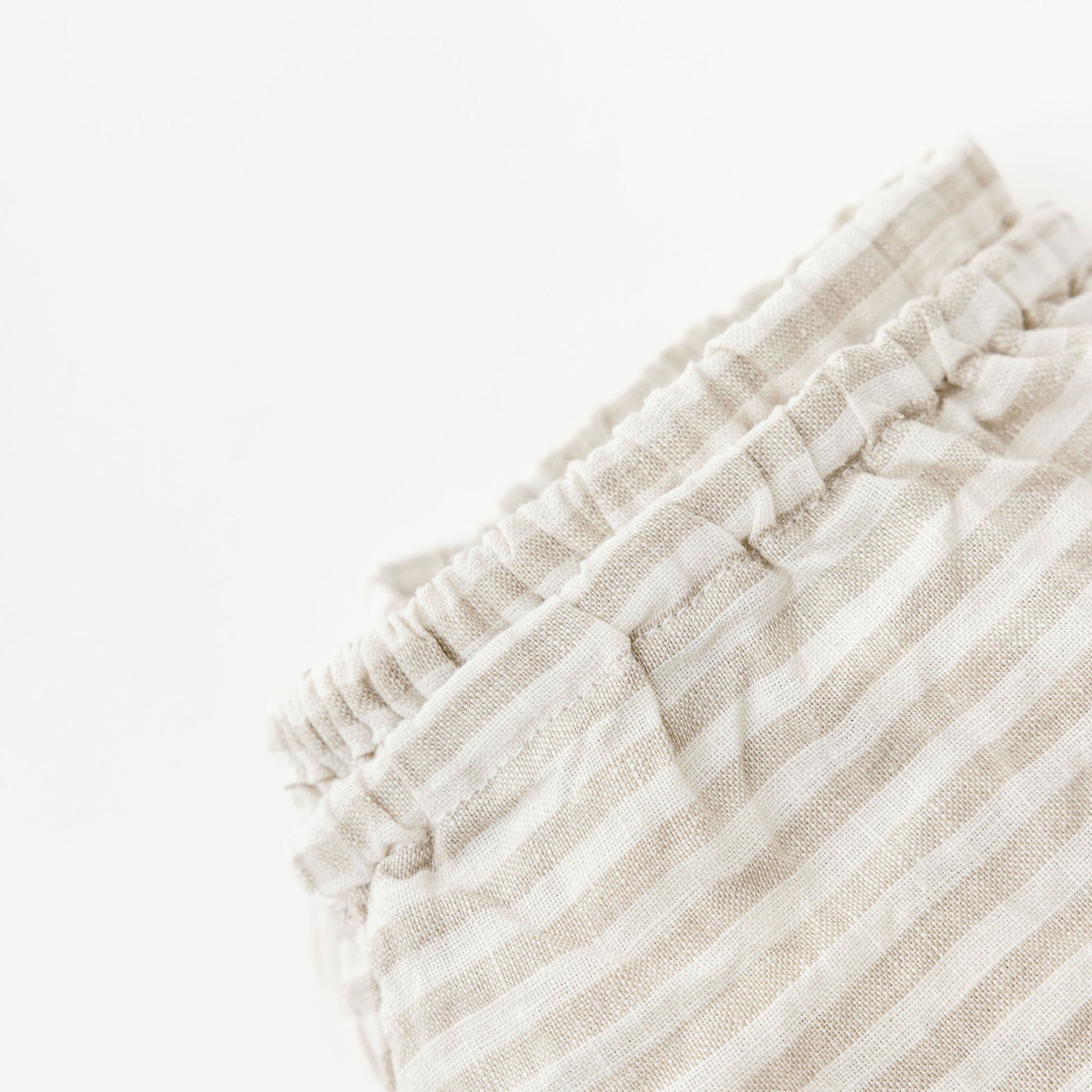 Foxtrot Home French Flax Linen styled in a baby's bedroom with Sand Stripes Cot Sheet and Bassinet Sheets.